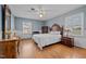 Cozy bedroom featuring wood floors, a dresser, and ample natural light from multiple windows at 102 Trinity Dr, Elon, NC 27244