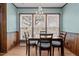Bright dining area features a chandelier, wood-paneled walls, and windows overlooking the outdoors at 102 Trinity Dr, Elon, NC 27244