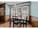 Charming dining area featuring wood-paneled walls, three windows, and classic chandelier at 102 Trinity Dr, Elon, NC 27244