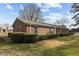 Classic brick home with black shutters and lush green hedges, offering a timeless aesthetic at 102 Trinity Dr, Elon, NC 27244