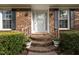 Welcoming front porch with brick steps, white railings, and charming flower pots at 102 Trinity Dr, Elon, NC 27244