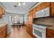 Cozy kitchen with wooden cabinets, white appliances, and a charming dining area at 102 Trinity Dr, Elon, NC 27244
