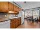 Functional kitchen with wooden cabinets, a sink, and dining area in the background at 102 Trinity Dr, Elon, NC 27244