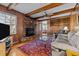 Spacious living room with wood paneling, a brick fireplace, and comfortable seating at 102 Trinity Dr, Elon, NC 27244