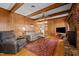 Welcoming living room with wood paneling, cozy seating, and a brick fireplace at 102 Trinity Dr, Elon, NC 27244