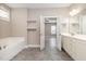 A bathroom featuring a soaking tub, white vanity, neutral color palette and a door to another room at 104 Coats Ridge Dr, Benson, NC 27504