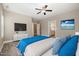 A comfortably furnished bedroom offers a ceiling fan, a TV, a plush bed, and a view to the bathroom at 104 Coats Ridge Dr, Benson, NC 27504