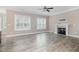 Open living room with wood-look flooring, fireplace, and bright windows at 104 Coats Ridge Dr, Benson, NC 27504