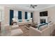 Bright living room with fireplace, ceiling fan, plush seating, and large windows with elegant curtains at 104 Coats Ridge Dr, Benson, NC 27504