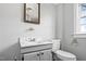 Vintage bathroom with a sink, mirror, and a standard toilet at 107 N 12Th St, Erwin, NC 28339