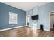 This bedroom features hardwood floors, a window with blinds, and a television mounted on the wall at 107 N 12Th St, Erwin, NC 28339