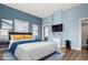 Comfortable bedroom featuring a bed with yellow pillows and a blue blanket, with a TV mounted on the wall at 107 N 12Th St, Erwin, NC 28339