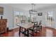 Dining area featuring a large window, hardwood floors, stylish lighting fixture, and access to the backyard at 11 D'Ango Cir, Angier, NC 27501