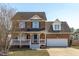 Charming two-story brick home with a welcoming front porch and well-maintained landscaping on a sunny day at 11 D'Ango Cir, Angier, NC 27501