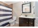 This bathroom has a single sink vanity with a dark cabinet and a shower with a blue and white shower curtain at 113 Palladium Ct, Elon, NC 27244