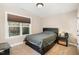 Well-lit bedroom with a large window, plush carpet, and modern black furniture at 113 Palladium Ct, Elon, NC 27244