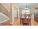 Formal dining room with hardwood floors, chandelier, and large window for natural light at 113 Palladium Ct, Elon, NC 27244