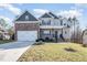 Lovely two-story home showcasing a covered porch, two-car garage, and well-maintained landscaping at 113 Palladium Ct, Elon, NC 27244