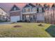 Charming two-story home featuring a stone facade, covered porch, and well-manicured lawn at 113 Palladium Ct, Elon, NC 27244