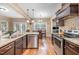 Kitchen with stainless steel appliances, granite countertops, dark cabinetry, and hardwood floors at 113 Palladium Ct, Elon, NC 27244