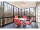 Cozy screened-in porch with a glass table and comfortable red chairs, perfect for outdoor relaxation at 113 Palladium Ct, Elon, NC 27244