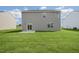 Expansive green backyard of a two-story home featuring light grey siding and a patio at 113 Paper Birch Way, Fuquay Varina, NC 27526