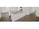 Open concept kitchen with an island and stainless steel sink with modern grey-brown flooring at 113 Paper Birch Way, Fuquay Varina, NC 27526