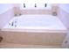 Luxurious soaking bathtub with neutral tile surround and bright natural light at 1136 Knotty Oaks Dr, Apex, NC 27523