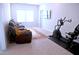 Carpeted bonus room with a comfortable sofa, large window, television and exercise bicycle at 1136 Knotty Oaks Dr, Apex, NC 27523