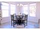 Bright dining area with table and four chairs set by the natural light from the large windows at 1136 Knotty Oaks Dr, Apex, NC 27523