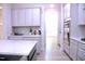 Modern kitchen with white cabinets, light countertops, stainless steel appliances, and wood floors at 1136 Knotty Oaks Dr, Apex, NC 27523