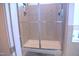 Modern shower with glass door and neutral tile and stone-look base at 1136 Knotty Oaks Dr, Apex, NC 27523