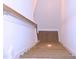 View down wooden stairs and railing, with carpeted landing for safe, comfortable transition to lower level at 1136 Knotty Oaks Dr, Apex, NC 27523