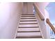 White and wood staircase, showing carpeted steps, offering an elegant design feature with safe and comfortable movement at 1136 Knotty Oaks Dr, Apex, NC 27523