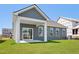 Back of house featuring covered patio with sliding glass doors leading to green grass of backyard at 121 Willow Cameron Way, Angier, NC 27501