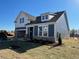 New home showing gray siding, stone accents, a two-car garage, and a well-maintained lawn at 121 Willow Cameron Way, Angier, NC 27501