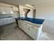 Unfinished kitchen featuring white cabinets, a large island, and access to a staircase at 121 Willow Cameron Way, Angier, NC 27501