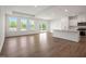Spacious living room with tray ceiling, large windows, and an open layout with the kitchen at 121 Willow Cameron Way, Angier, NC 27501