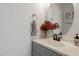 Cozy bathroom with a gray vanity, white sink, round mirror, and decorative floral arrangement at 1218 Twelve Oaks Ln, Apex, NC 27502