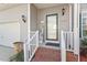 Front entrance with a white-railed porch and brick steps, plus a welcome sign and potted plants at 1218 Twelve Oaks Ln, Apex, NC 27502