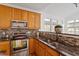 Bright kitchen boasting stainless steel appliances, granite counters, and mosaic backsplash at 1218 Twelve Oaks Ln, Apex, NC 27502