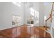 Bright living room with hardwood floors, large windows, and a staircase leading to the upper level at 1218 Twelve Oaks Ln, Apex, NC 27502