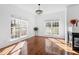 Bright living room with hardwood floors, large windows, and a stylish chandelier adding elegance at 1218 Twelve Oaks Ln, Apex, NC 27502