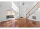 Bright living room with hardwood floors, a staircase, and large windows providing ample natural light at 1218 Twelve Oaks Ln, Apex, NC 27502