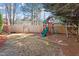 Backyard with a playground set surrounded by a wooden fence, providing a safe play area at 1218 Twelve Oaks Ln, Apex, NC 27502