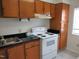 Functional kitchen featuring wooden cabinets, a white stove, and ample counter space for food preparation at 139 Kingsbury Dr, Chapel Hill, NC 27514