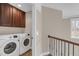 Upstairs laundry room features washer, dryer, and cabinets at 1426 Phelps Ridge Dr, Fuquay Varina, NC 27526