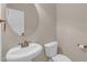 Classic powder room features pedestal sink, toilet, and round mirror at 1426 Phelps Ridge Dr, Fuquay Varina, NC 27526