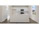 Bright kitchen features white cabinets, stainless steel appliances, a central island, and hardwood floors at 144 Paper Birch Way, Fuquay Varina, NC 27526