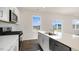 Modern kitchen boasts stainless appliances, white cabinetry, an island with sink, and hardwood floors at 144 Paper Birch Way, Fuquay Varina, NC 27526